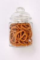 Pretzel cracker in a glass jar on white background photo