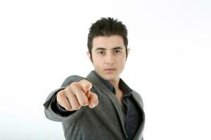 Middle eastern Caucasian young office business man wearing suit point finger at camera on white studio background focus on hand photo