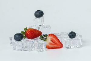Strawberry blueberry berry read black ice cube on white background photo