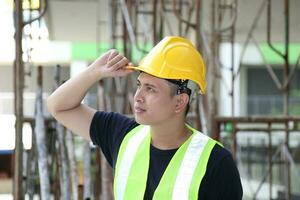 South East Asian young Malay Chinese man woman wearing safely helmet construction site work photo