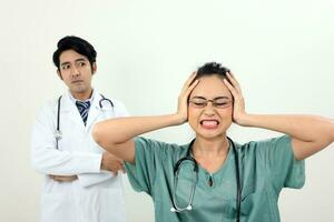 young asian malay chinese male female doctor on white background headache angry annoyed hand on head at camera photo