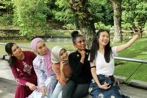 group of five woman Malay Chinese Indian Asian Malaysian outdoor green park lake nature selfie smartphone camera self portrait photo