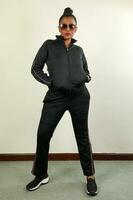 Asian Indian woman wearing sunglass track suit pose hip hop style modern funky photo