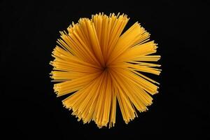 dry raw spaghetti black background blooming flower sunray glow pattern concept photo