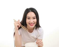 Beautiful young south east Asian woman holding chinese empty chopstick soup spoon bowl utensil pretend acting posing see eat taste feed offer satisfaction yummy white background happy photo