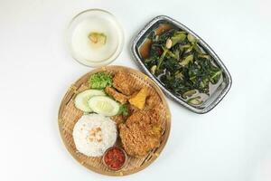Ayam penyet East Javanese cuisine smashed fried chicken dish with floss sambal slices of cucumbers fried tofu and tempeh Stair fired green Chinese broccoli garlic oyster sauce soup photo