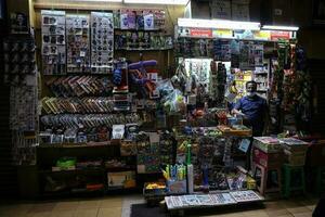 Kuala Lumpur, Malaysia-September 11, 2020- A owner of street side in the wall convenience store looks on in the evening, slow struggling market in covid-19 pandemic photo