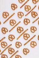 Pretzel cracker sticks laid in rows design angle straight on what background photo