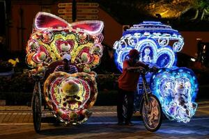 Melaka, Malaysia-September 24, 2020- due to pandemic covid-19 one of the most third hit business is tourism sector. Domestic tourism seeing some recovery. Trishaw decorated with light and dolls. photo