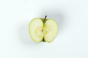 Green apple half cut slice top view on white background photo