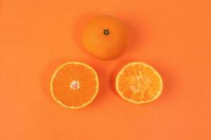 Mandarin Orange Fruit slice half juiced extracted on orange background photo