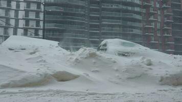 Cars covered by snow after a snow blizzard. Residential building in the background video