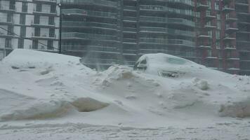 Autos bedeckt durch Schnee nach ein Schnee Schneesturm. Wohn Gebäude im das Hintergrund video