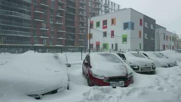 bilar täckt förbi snö efter en snö snöstorm. bostads- byggnad i de bakgrund video