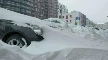 Cars covered by snow after a snow blizzard. Residential building in the background video