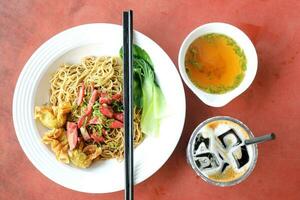 Springy egg noodle with roasted sliced chicken Chinese cabbage and fried dim sum dumpling photo