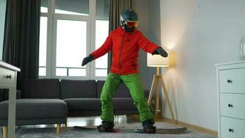 Diversão vídeo. homem vestido Como uma snowboarder passeios uma snowboard em uma tapete dentro uma acolhedor quarto video