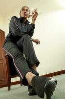 Asian Indian woman wearing black track suit sit pose hip hop style modern funky photo