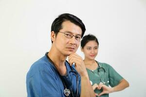 Young Asian male female doctor wearing apron uniform tunic stethoscope look at camera hart hand sing photo