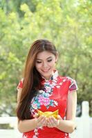 Young south east asian Chinese man woman traditional costume Chinese new year greeting outdoors at temple photo