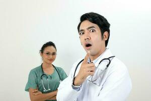 young asian malay chinese male female doctor on white background finger on chin thinking wonder mouth open at camera photo