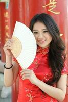 Young south east asian Chinese man woman traditional costume Chinese new year greeting outdoors at temple photo