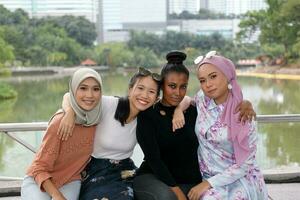 Group of woman Malay Chinese Indian Malaysian  hug friends togetherness unity outdoor green park lake nature photo