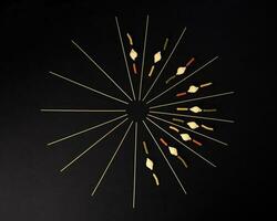 dry raw spaghetti conchiglie seashells fusilli cork screw color pasta laid on black background sunray glow pattern concept photo
