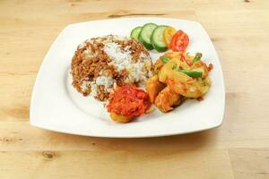 Turmeric Friend Chicken with vegetable white rice topped with dark sauce ayam goreng kunyit photo