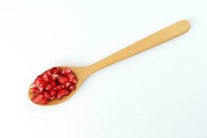 Red Pomegranate seed wooden spoon white background photo