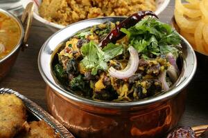 Bengali Iftar Ramadan breakfast spread ripe dates peep fried spicy piaju onion fitter eggplant tanpura potato chop haleem jilapi khichuri rice chana sola curry on rustic wooden table photo