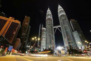 Kuala Lumpur, Malaysia-February 12, 2020  Street level view of the Petronas Twin Towers a tourist attraction and a commercial centre. with car light trails photo