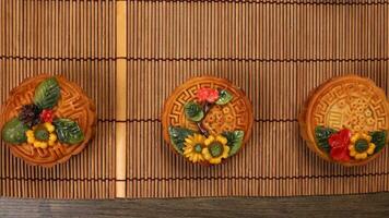 Colorful flower decorated mooncake Chinese mid autumn festival on bamboo food mat background photo