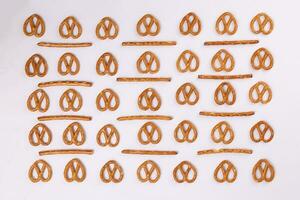 Pretzel cracker sticks laid in rows design angle straight on what background photo