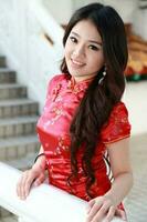 Young south east asian Chinese man woman traditional costume Chinese new year greeting outdoors at temple photo