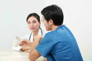 Young Asian male female doctor wearing apron uniform stethoscope female patient talk discuss cheek photo