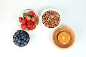 Blueberry Strawberry Herb Spice Almond Cashew Nut Mandarin Orange in bowl on white background photo