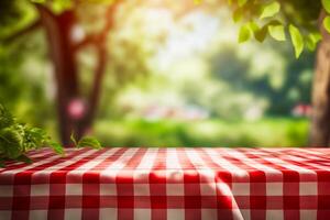 Red and white checkered tablecloth with tree in the background. photo