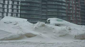 auto's gedekt door sneeuw na een sneeuw sneeuwstorm. woon- gebouw in de achtergrond video