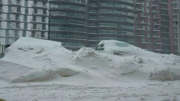 bilar täckt förbi snö efter en snö snöstorm. bostads- byggnad i de bakgrund video