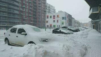 Cars covered by snow after a snow blizzard. Residential building in the background video