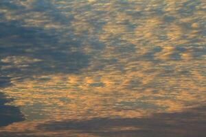 Evening altocumulus clouds Like a flock of mackerel and a flock of sheep floating in a beautiful sky in a rural area in Thailand, when the sun has set, it is a panoramic view of warmth, romance, peace photo