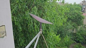 Starlink satellite dish, an internet constellation operated by SpaceX, is installed on the wall of an apartment building. video