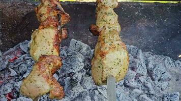 Grilled baked meat strung on skewers is grilled with hot coals and smoke. The skewers spin automatically. video