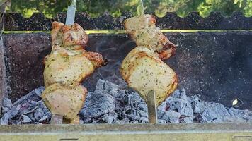 Grilled baked meat strung on skewers is grilled with hot coals and smoke. The skewers spin automatically. video