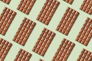 Chocolate bar pattern flat lay, top view on pastel green background photo