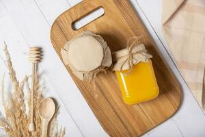 Jars with honey and nuts honey on wooden background top view, flat lay photo