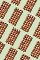 Chocolate bar pattern flat lay, top view on pastel green background photo