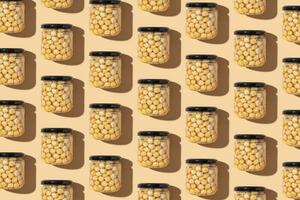 Pattern with glass jar with honey and nuts on beige background. Hazelnuts in honey. Top view photo