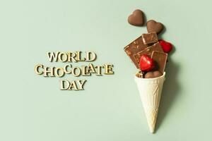 World chocolate day text with chocolate flat lay, top view on pastel green background photo